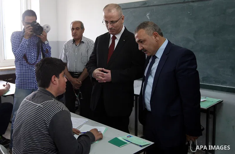 Palestinian Prime Minister Rami Hamdallah visits a school during the first day of high school exams, known as "Tawjihi", in the West Bank city of Ramallah, on May 30, 2015. Nearly 81,000 Palestinian students sat for the...