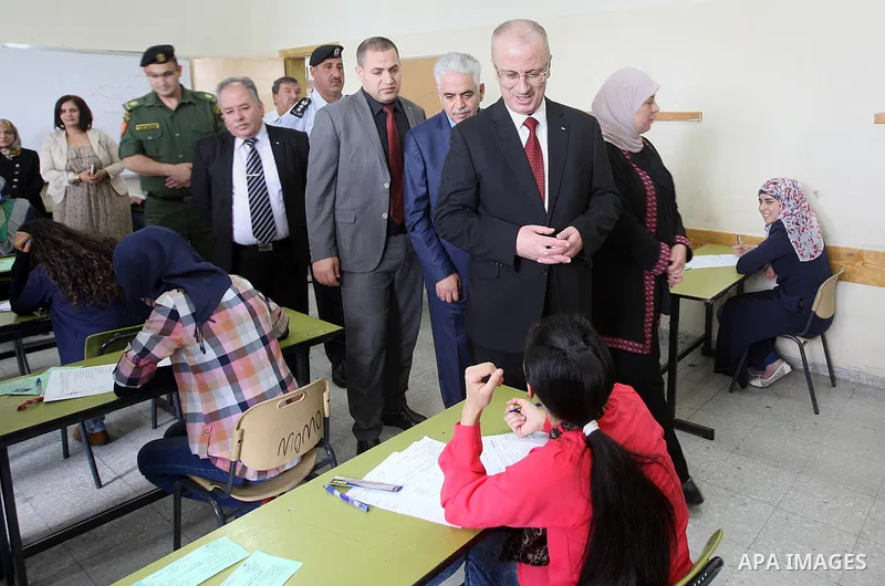 Palestinian Prime Minister Rami Hamdallah visits a school during the first day of high school exams, known as "Tawjihi", in the West Bank city of Ramallah, on May 30, 2015. Nearly 81,000 Palestinian students sat for the...
