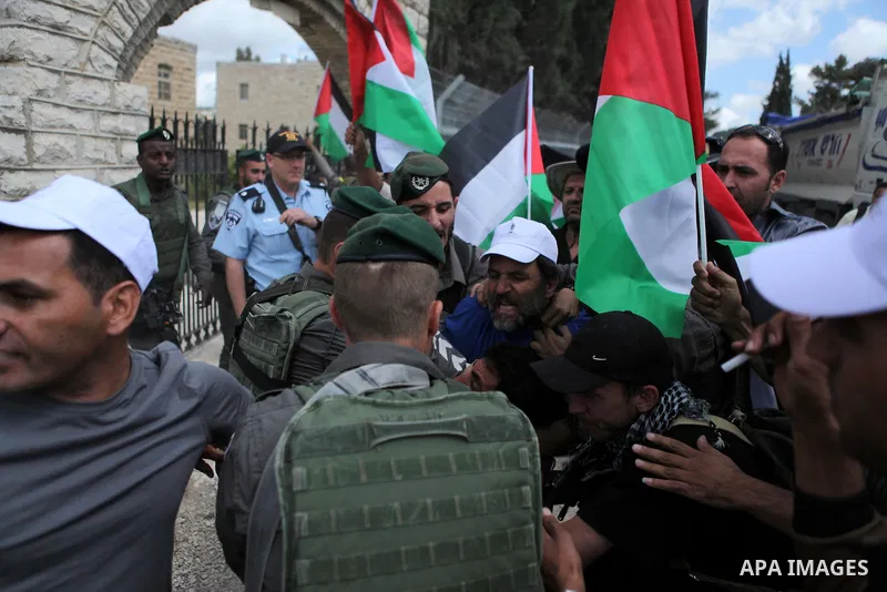 Israeli security try to detain a Palestinian and Israeli protesters during a demonstration outside al-Barak building, near al-Aroub Palestinian refugee camp, just north the West Bank town of Hebron on May 30, 2015, again...