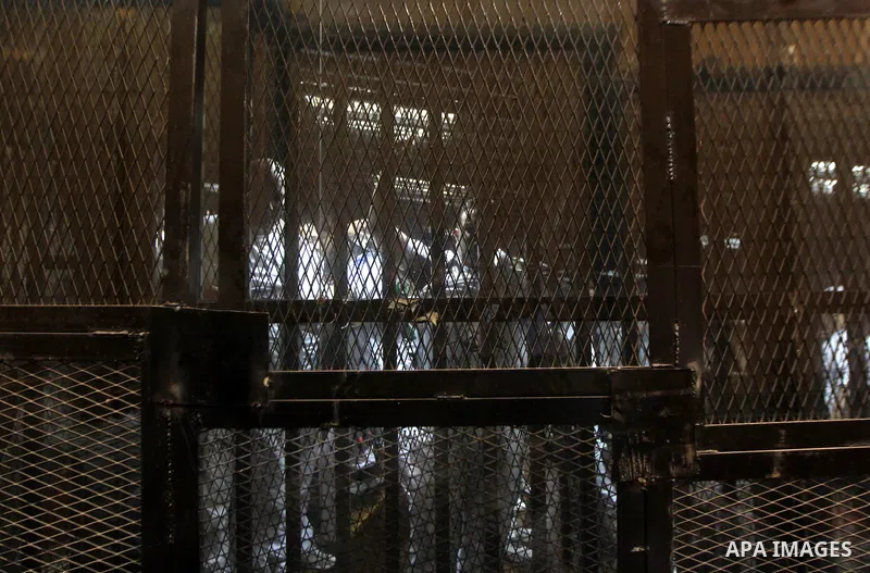 Egyptian defendants sit behind bars during their trial over a 2012 stadium riot in the canal city of Port Said that left 74 people dead on May 30, 2015 at the police academy in Cairo. The Egyptian court postponed its ver...