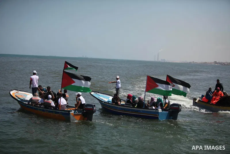 Palestinians hold flags as they ride a boat during a rally marking the 5th anniversary of the Mavi Marmara Gaza flotilla incident, at the seaport of Gaza City May 31, 2015. Nine activists, eight Turkish and one Turkish-A...