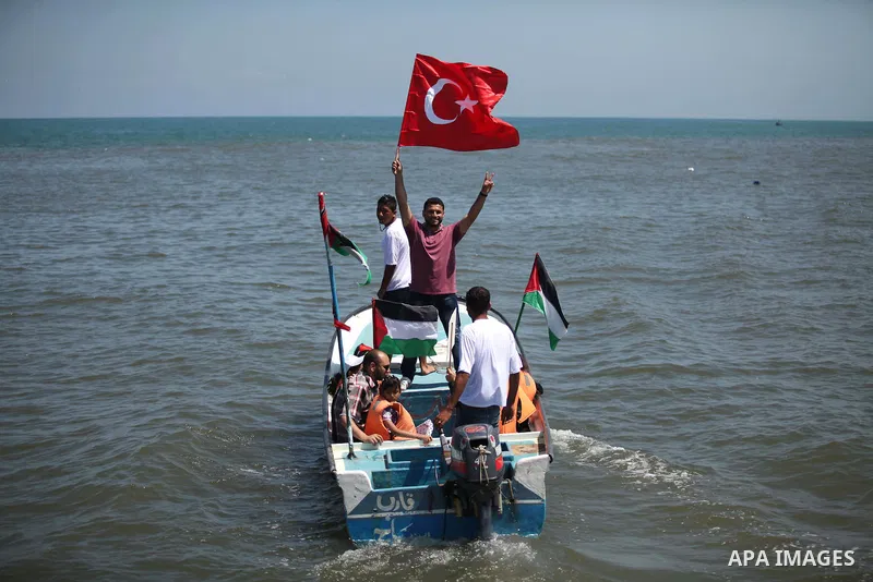 Palestinians hold flags as they ride a boat during a rally marking the 5th anniversary of the Mavi Marmara Gaza flotilla incident, at the seaport of Gaza City May 31, 2015. Nine activists, eight Turkish and one Turkish-A...