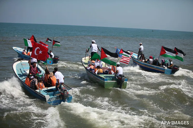 Palestinians hold flags as they ride a boat during a rally marking the 5th anniversary of the Mavi Marmara Gaza flotilla incident, at the seaport of Gaza City May 31, 2015. Nine activists, eight Turkish and one Turkish-A...