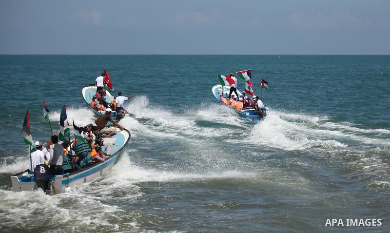 Palestinians hold flags as they ride a boat during a rally marking the 5th anniversary of the Mavi Marmara Gaza flotilla incident, at the seaport of Gaza City May 31, 2015. Nine activists, eight Turkish and one Turkish-A...