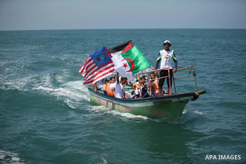 Palestinians hold flags as they ride a boat during a rally marking the 5th anniversary of the Mavi Marmara Gaza flotilla incident, at the seaport of Gaza City May 31, 2015. Nine activists, eight Turkish and one Turkish-A...