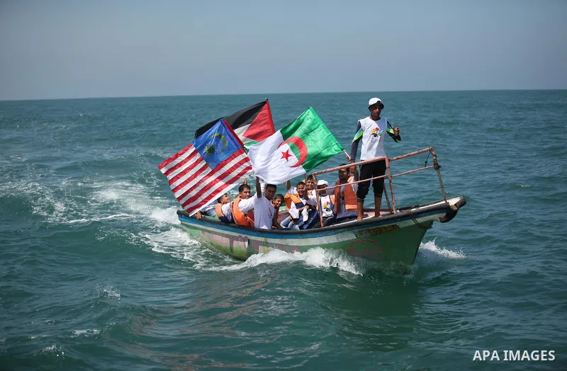 Palestinians hold flags as they ride a boat during a rally marking the 5th anniversary of the Mavi Marmara Gaza flotilla incident, at the seaport of Gaza City May 31, 2015. Nine activists, eight Turkish and one Turkish-A...