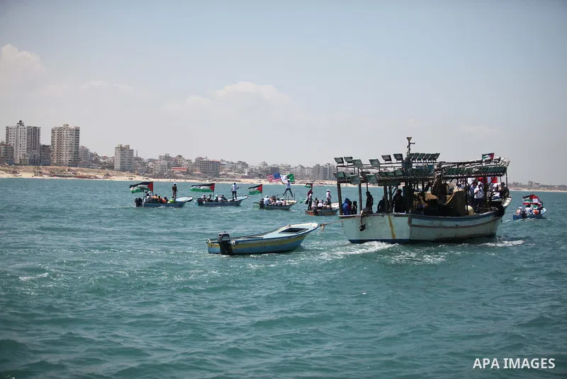 Palestinians hold flags as they ride a boat during a rally marking the 5th anniversary of the Mavi Marmara Gaza flotilla incident, at the seaport of Gaza City May 31, 2015. Nine activists, eight Turkish and one Turkish-A...