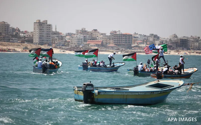 Palestinians hold flags as they ride a boat during a rally marking the 5th anniversary of the Mavi Marmara Gaza flotilla incident, at the seaport of Gaza City May 31, 2015. Nine activists, eight Turkish and one Turkish-A...