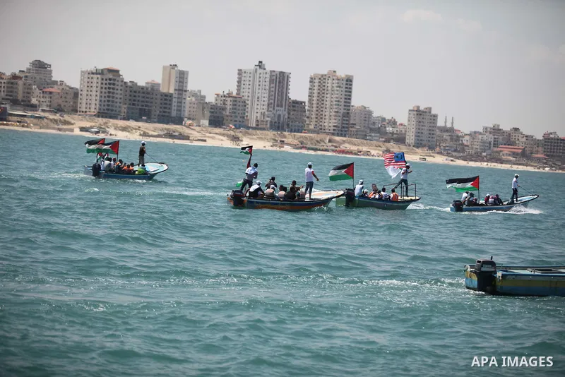Palestinians hold flags as they ride a boat during a rally marking the 5th anniversary of the Mavi Marmara Gaza flotilla incident, at the seaport of Gaza City May 31, 2015. Nine activists, eight Turkish and one Turkish-A...