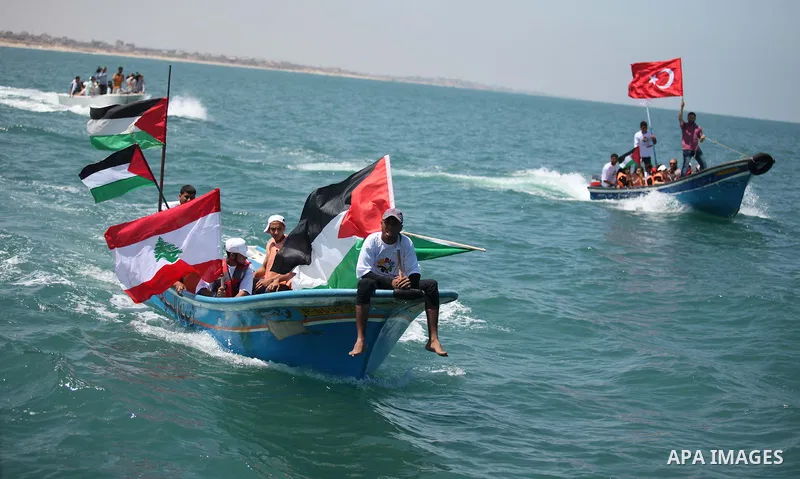 Palestinians hold flags as they ride a boat during a rally marking the 5th anniversary of the Mavi Marmara Gaza flotilla incident, at the seaport of Gaza City May 31, 2015. Nine activists, eight Turkish and one Turkish-A...