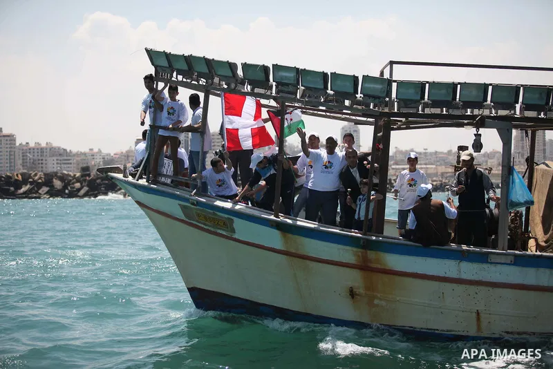 Palestinians hold flags as they ride a boat during a rally marking the 5th anniversary of the Mavi Marmara Gaza flotilla incident, at the seaport of Gaza City May 31, 2015. Nine activists, eight Turkish and one Turkish-A...