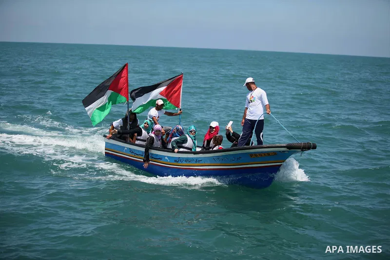 Palestinians hold flags as they ride a boat during a rally marking the 5th anniversary of the Mavi Marmara Gaza flotilla incident, at the seaport of Gaza City May 31, 2015. Nine activists, eight Turkish and one Turkish-A...