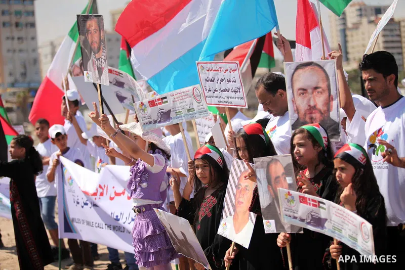 Palestinians hold flags during a rally marking the 5th anniversary of the Mavi Marmara Gaza flotilla incident, at the seaport of Gaza City May 31, 2015. Nine activists, eight Turkish and one Turkish-American, died on May...