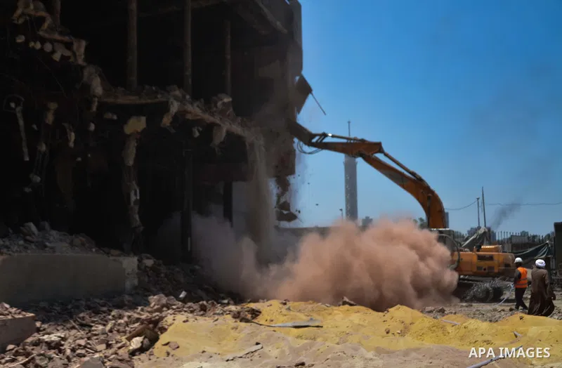 Egyptian workers use a bulldozer during the demolition of the headquarters of the once-dominant party of ex-president Hosni Mubarak that was torched during the 2011 uprising that toppled him, on May 31, 2015 in the capit...