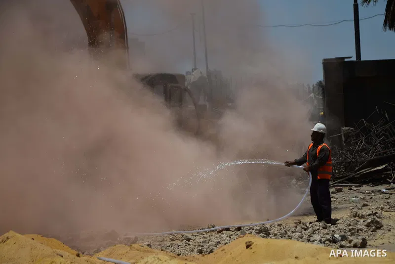An Egyptian worker sprays water during the demolition of the headquarters of the once-dominant party of ex-president Hosni Mubarak that was torched during the 2011 uprising that toppled him, on May 31, 2015 in the capita...