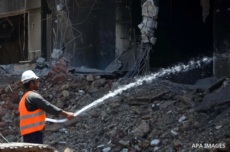 An Egyptian worker sprays water during the demolition of the headquarters of the once-dominant party of ex-president Hosni Mubarak that was torched during the 2011 uprising that toppled him, on May 31, 2015 in the capita...