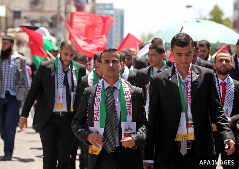 Palestinian grooms take part in a mass wedding ceremony in Gaza city on May 31, 2015. Nearly 4000 Palestinian couples were married in a ceremony funded by Turkish government. Photo by Ashraf Amra
