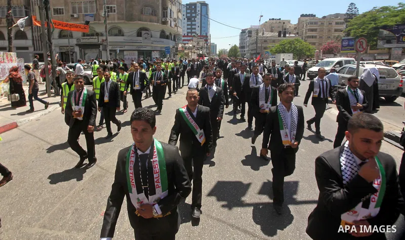 Palestinian grooms take part in a mass wedding ceremony in Gaza city on May 31, 2015. Nearly 4000 Palestinian couples were married in a ceremony funded by Turkish government. Photo by Ashraf Amra