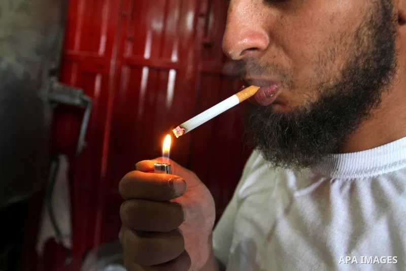 A Palestinian man smokes cigarettes in the southern Gaza Strip City of Rafah, on May 23, 2015. Smuggling through tunnels began several months after Islamic Hamas movement's control of the Gaza Strip and the Israeli block...