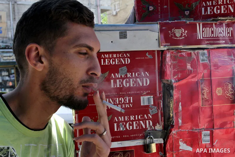 A Palestinian man smokes cigarettes in the southern Gaza Strip City of Rafah, on May 23, 2015. Smuggling through tunnels began several months after Islamic Hamas movement's control of the Gaza Strip and the Israeli block...