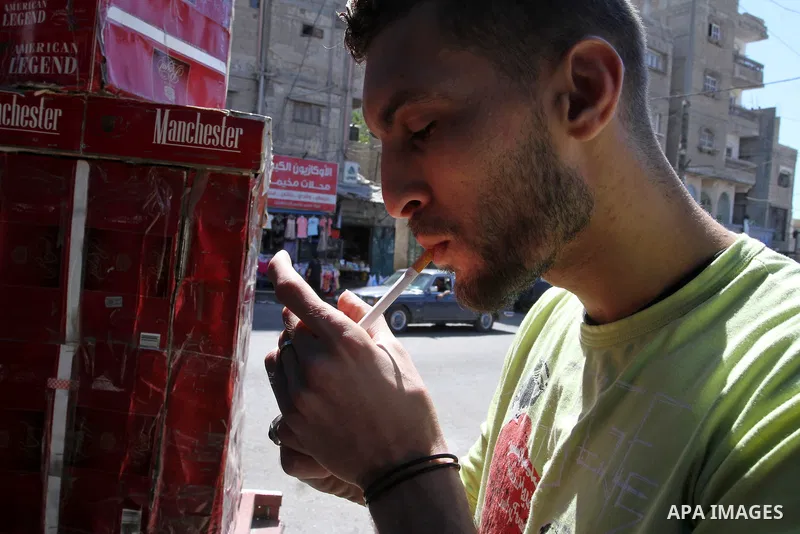A Palestinian man smokes cigarettes in the southern Gaza Strip City of Rafah, on May 23, 2015. Smuggling through tunnels began several months after Islamic Hamas movement's control of the Gaza Strip and the Israeli block...