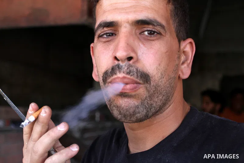 A Palestinian man smokes cigarettes in the southern Gaza Strip City of Rafah, on May 23, 2015. Smuggling through tunnels began several months after Islamic Hamas movement's control of the Gaza Strip and the Israeli block...