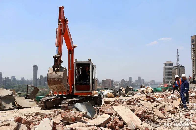 Egyptian workers use a bulldozer during the demolition of the headquarters of the once-dominant party of ex-president Hosni Mubarak that was torched during the 2011 uprising that toppled him, on May 31, 2015 in the capit...