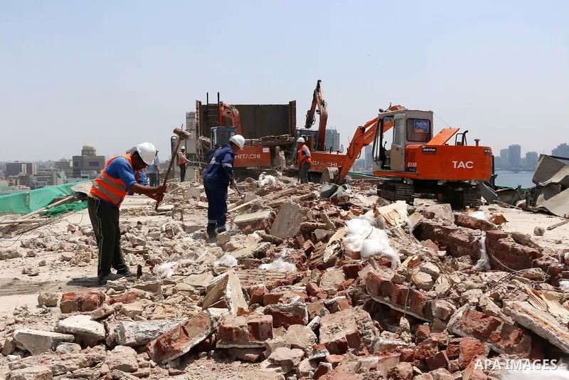 Egyptian workers use a bulldozer during the demolition of the headquarters of the once-dominant party of ex-president Hosni Mubarak that was torched during the 2011 uprising that toppled him, on May 31, 2015 in the capit...