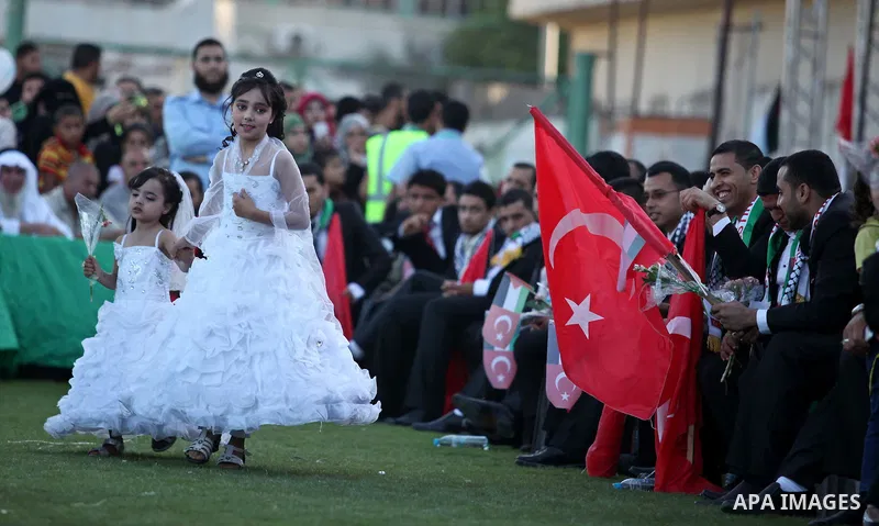 Palestinian girls attend in a mass wedding ceremony in Gaza City, on May 31, 2015. Nearly 2000 Palestinian couples were married in a ceremony funded by the Turkish government and supported by the Hamas movement. Photo by...