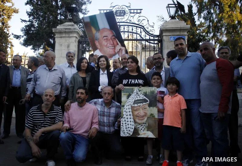 Palestinians take part in a memorial ceremony marking the 14th anniversary of the death of Faisal al-Husseini, Palestinian Authority's representative for Jerusalem affairs, outside the Orient House, which used to be the...