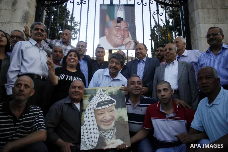 Palestinians take part in a memorial ceremony marking the 14th anniversary of the death of Faisal al-Husseini, Palestinian Authority's representative for Jerusalem affairs, outside the Orient House, which used to be the...