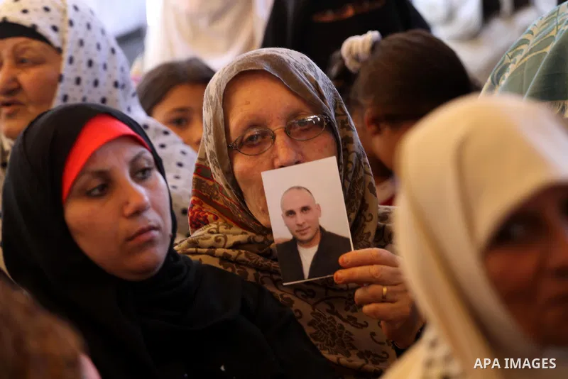 Palestinians hold pictures of prisoners held in Israeli jails, during a protest, in front of Red cross office, in Gaza city, on June 01, 2015. Photo by Mohammed Asad