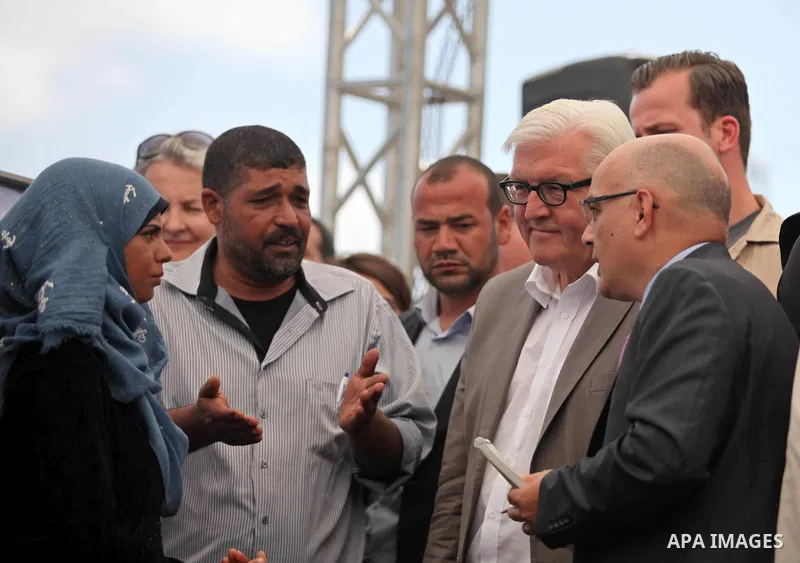 German Foreign Minister Frank-Walter Steinmeier speaks to a fisherman next to a destroyed rooms of Palestinian fishermen, damaged during Israeli Hamas conflict of 2014, in Gaza port, during his visit to Gaza City, 01 Jun...