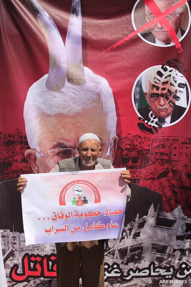 Palestinians take part in a protest marking the first anniversary of the Palestinian national unity government, in front of the headquarters of the Council of Ministers, in Gaza city on June 2, 2015. Photo by Ashraf Amra
