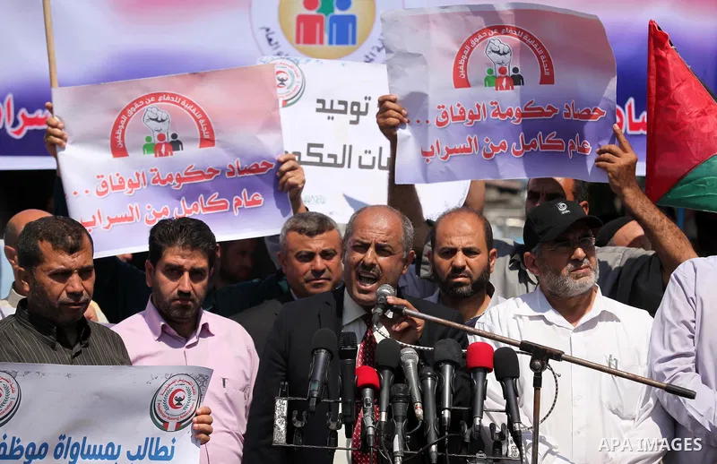 Palestinians take part in a protest marking the first anniversary of the Palestinian national unity government, in front of the headquarters of the Council of Ministers, in Gaza city on June 2, 2015. Photo by Ashraf Amra