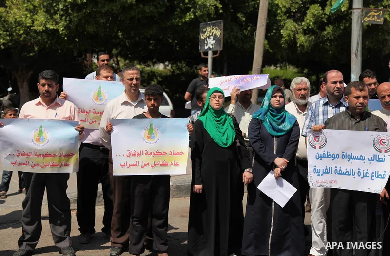 Palestinians take part in a protest marking the first anniversary of the Palestinian national unity government, in front of the headquarters of the Council of Ministers, in Gaza city on June 2, 2015. Photo by Ashraf Amra