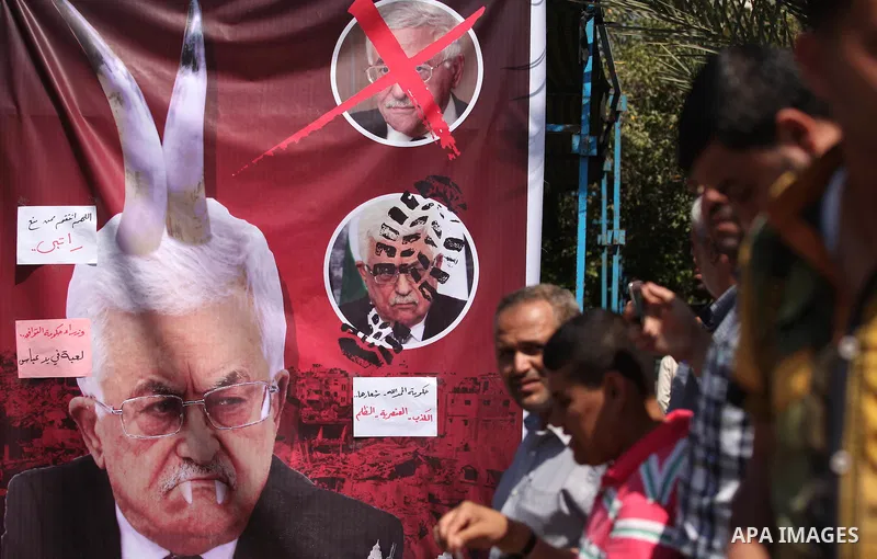 Palestinians take part in a protest marking the first anniversary of the Palestinian national unity government, in front of the headquarters of the Council of Ministers, in Gaza city on June 2, 2015. Photo by Ashraf Amra