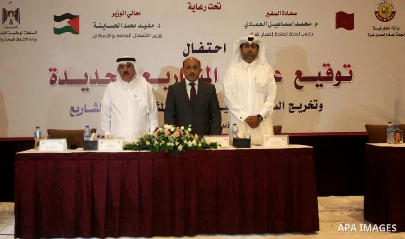 Palestinian housing minister Mufeed al-Hasayna, and Qatari ambassador Mohammed al-Emadi take part in a signing ceremony of agreement of new projects in Gaza city on June 2, 2015. Photo by Ashraf Amra
