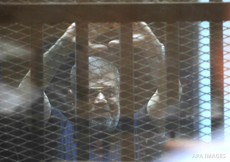 Ousted Egyptian president Mohamed Morsi gestures from the defendants cage as he attends his trial at the police academy on the outskirts of the capital Cairo on June 2, 2015. The Egyptian court postponed its final ruling...