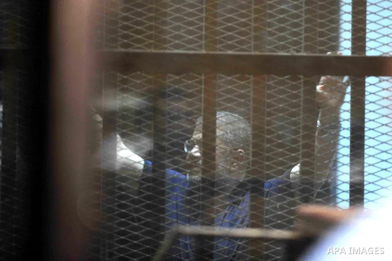 Ousted Egyptian president Mohamed Morsi gestures from the defendants cage as he attends his trial at the police academy on the outskirts of the capital Cairo on June 2, 2015. The Egyptian court postponed its final ruling...