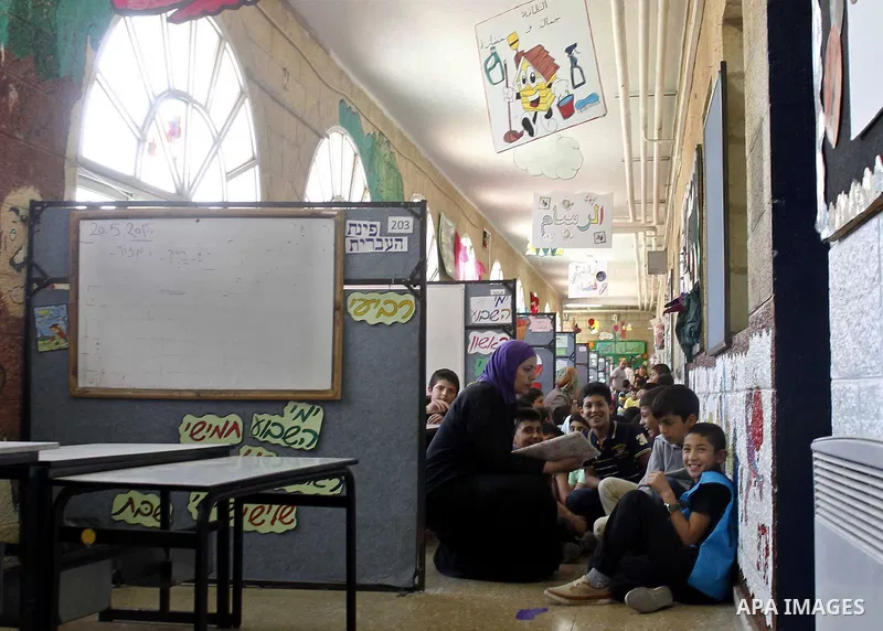 Israeli-Arab schoolchildren sit in the hallway at a school in Jerusalem after sirens sounded across Israel as part of country-wide massive civil defence exercise aimed at preparing the country for air or missile attacks...
