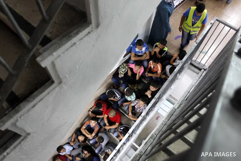 Israeli-Arab schoolchildren sit on stairs at a school in Jerusalem after sirens sounded across Israel as part of country-wide massive civil defence exercise aimed at preparing the country for air or missile attacks invol...