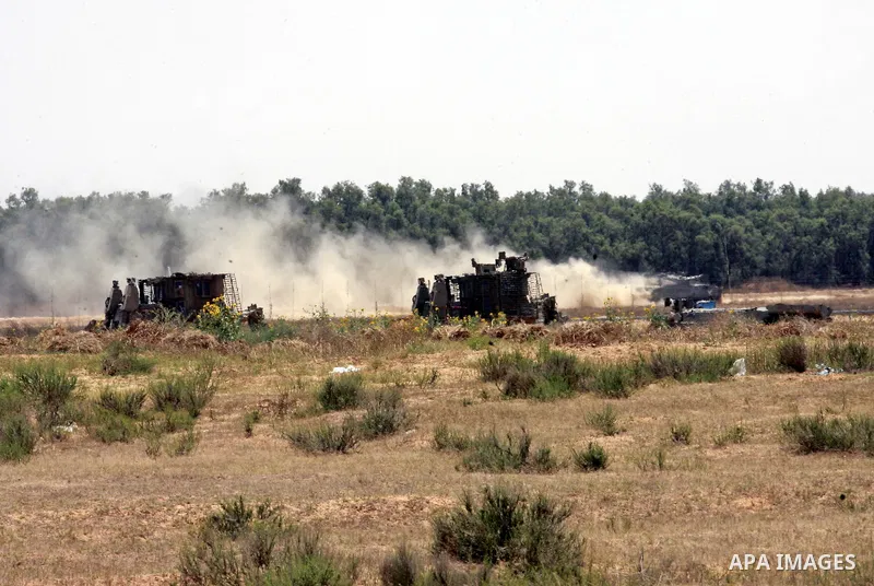 Israeli military bulldozers work along a barbed wire fence that separates Rafah in the southern Gaza Strip and the Israeli border, on June 03, 2015. Israeli troops backed by military vehicles and bulldozers pushed deep i...