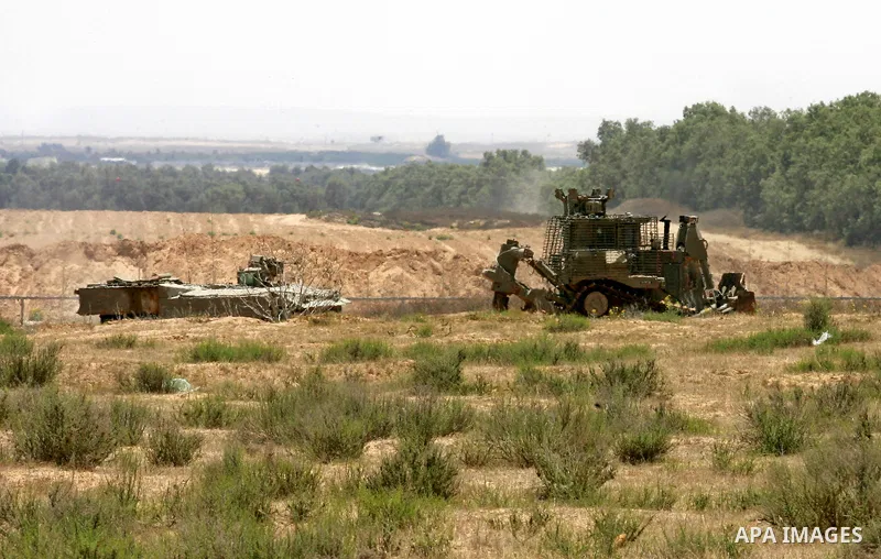 Israeli military bulldozers work along a barbed wire fence that separates Rafah in the southern Gaza Strip and the Israeli border, on June 03, 2015. Israeli troops backed by military vehicles and bulldozers pushed deep i...