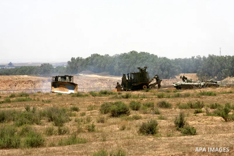 Israeli military bulldozers work along a barbed wire fence that separates Rafah in the southern Gaza Strip and the Israeli border, on June 03, 2015. Israeli troops backed by military vehicles and bulldozers pushed deep i...