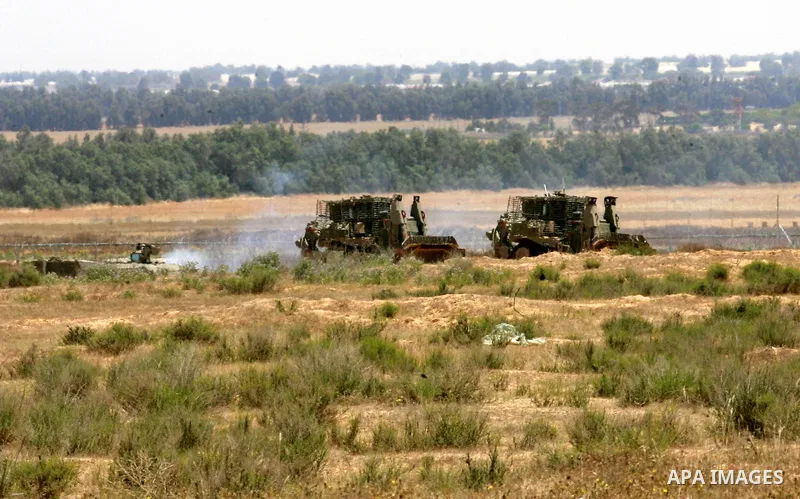 Israeli military bulldozers work along a barbed wire fence that separates Rafah in the southern Gaza Strip and the Israeli border, on June 03, 2015. Israeli troops backed by military vehicles and bulldozers pushed deep i...
