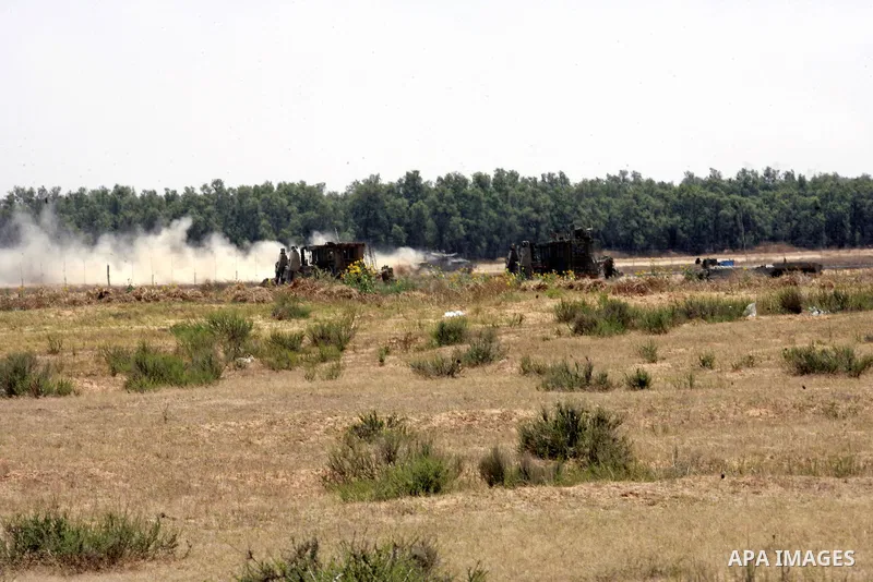 Israeli military bulldozers work along a barbed wire fence that separates Rafah in the southern Gaza Strip and the Israeli border, on June 03, 2015. Israeli troops backed by military vehicles and bulldozers pushed deep i...