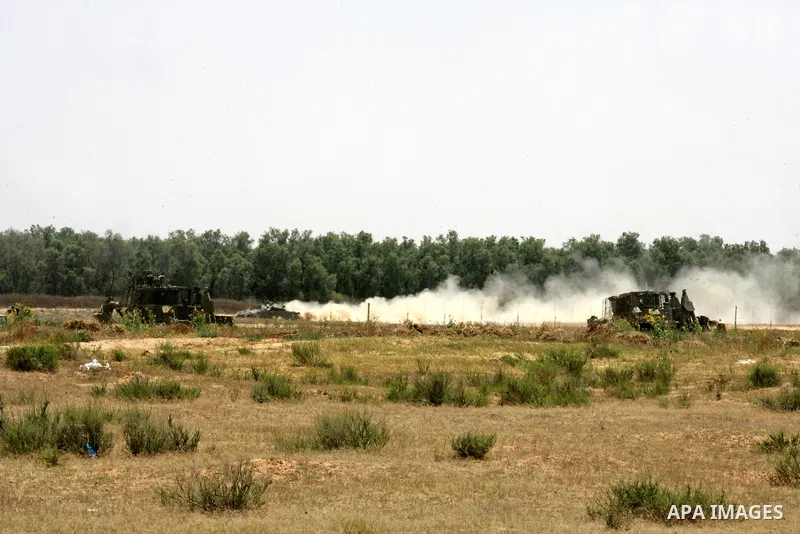 Israeli military bulldozers work along a barbed wire fence that separates Rafah in the southern Gaza Strip and the Israeli border, on June 03, 2015. Israeli troops backed by military vehicles and bulldozers pushed deep i...