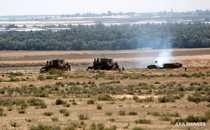 Israeli military bulldozers work along a barbed wire fence that separates Rafah in the southern Gaza Strip and the Israeli border, on June 03, 2015. Israeli troops backed by military vehicles and bulldozers pushed deep i...