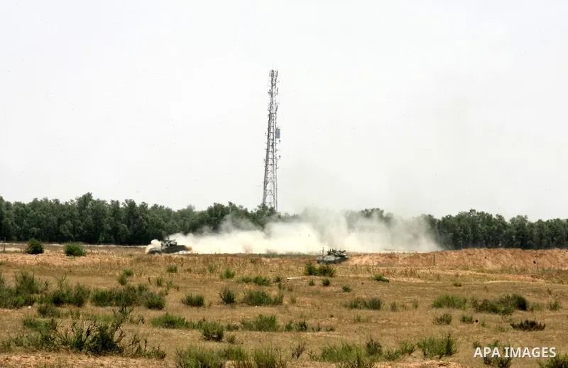 Israeli military bulldozers work along a barbed wire fence that separates Rafah in the southern Gaza Strip and the Israeli border, on June 03, 2015. Israeli troops backed by military vehicles and bulldozers pushed deep i...